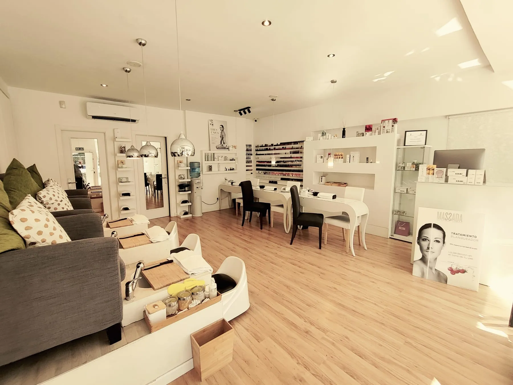 Sala del estudio a lo ancho: los sillones de pedicura a un lado y las mesas de manicura al fondo