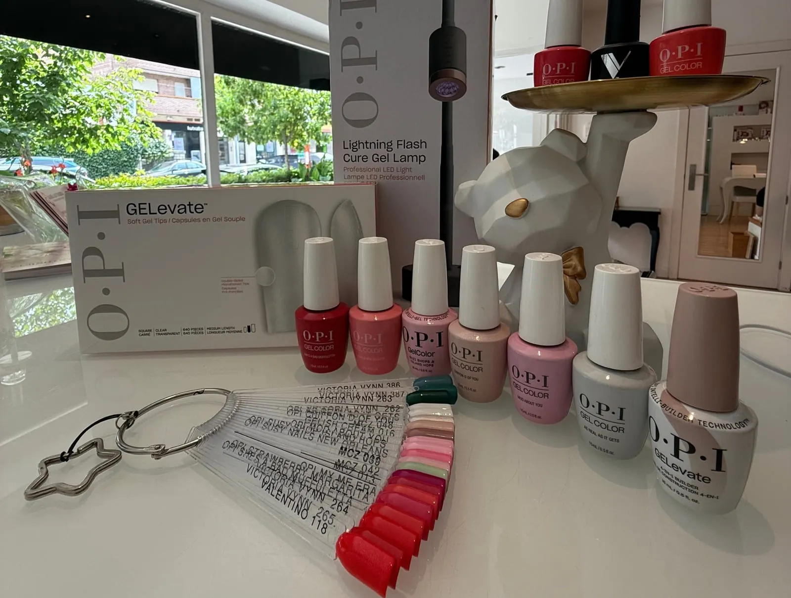 Esmaltes de gel OPI y muestrario de colores sobre la mesa del centro